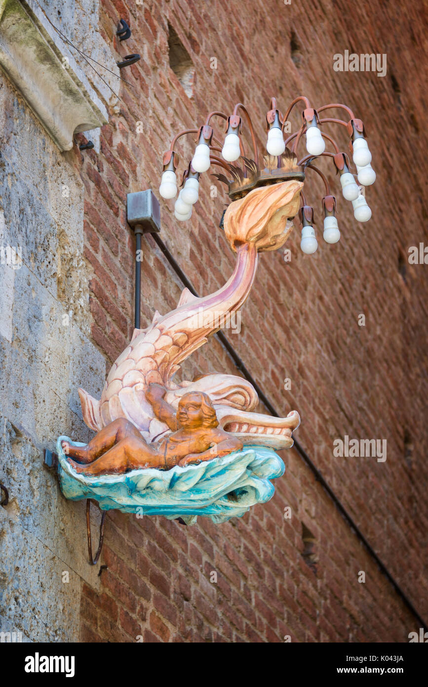Siena in Toscana, Italia - un delfino, emblema dell'Onda contrada (onda distretto) in una strada durante il famoso festival di palio Foto Stock
