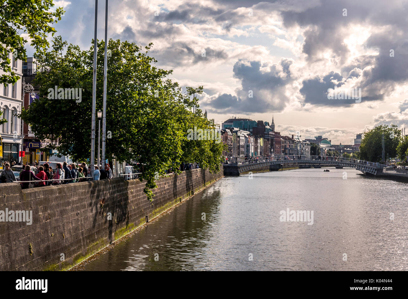 Persone attraversano Ha'penny Bridge attraverso il fiume Liffey nella capitale irlandese di Dublino Foto Stock