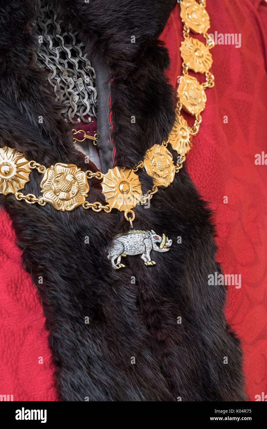 Dettaglio del xv secolo abbigliamento, chainmail e cinghiale emblema consumato sul campo di battaglia di Bosworth Storia viva Camp battaglia rievocazione evento, Inghilterra. Foto Stock