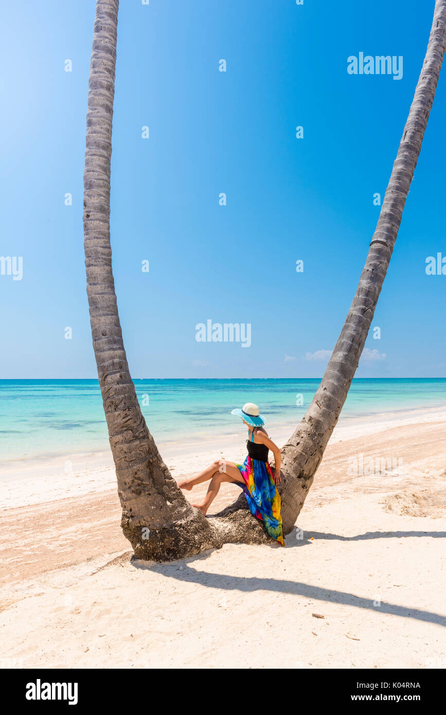 Spiaggia Juanillo (playa Juanillo), Punta Cana, Repubblica Dominicana. Donna sotto alte palme sulla spiaggia (MR) Foto Stock