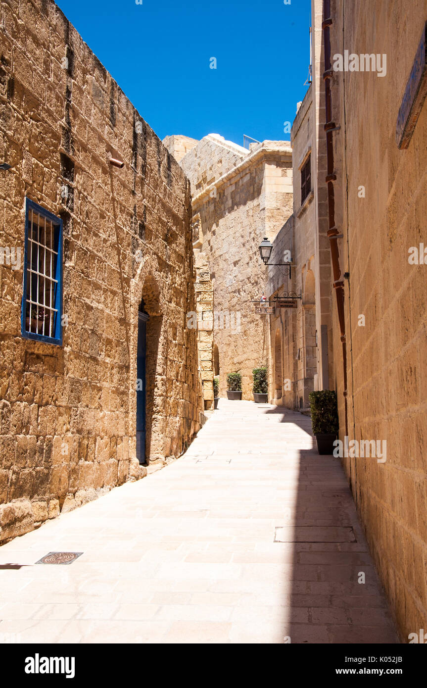 Una strada laterale in Victoria, la capitale dell'isola di Gozo nell'arcipelago Maltese. La ripresa è stata presa in una limpida giornata di sole. Foto Stock