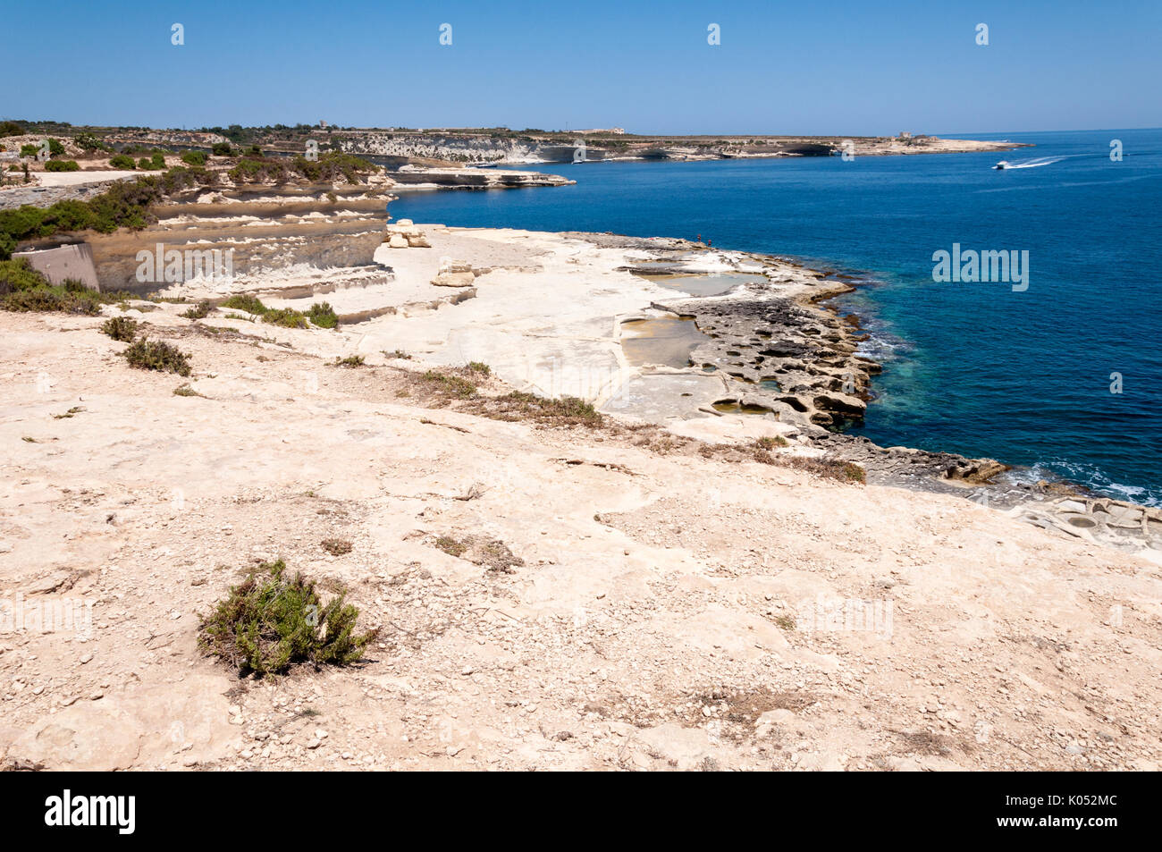 Vista guardando a nord da San Pietro piscina nella zona di Marsaxlokk sulla costa meridionale di Malta in una limpida giornata di sole Foto Stock