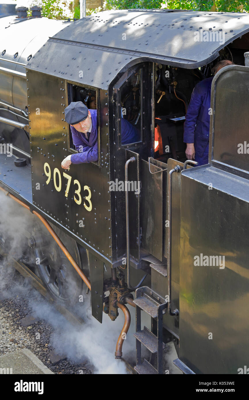 Driver e stoker nella cabina della locomotiva a vapore 90733 a Haworth stazione ferroviaria, Keighley e Worth Valley Railway, Haworth, West Yorkshire, Inghilterra. Foto Stock