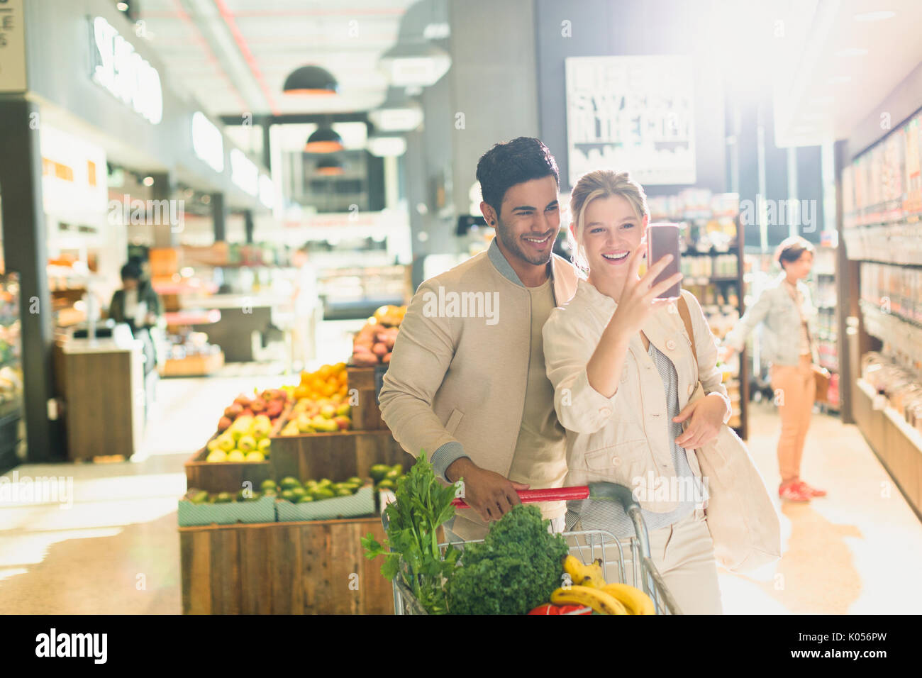 Sorridente coppia giovane tenendo selfie in drogheria market Foto Stock