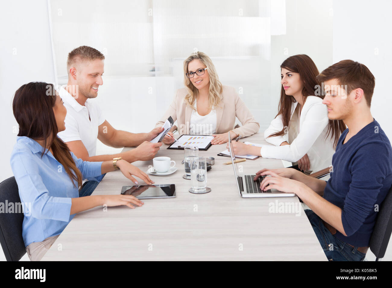 Ritratto di bella imprenditrice nell incontro con i colleghi in ufficio Foto Stock