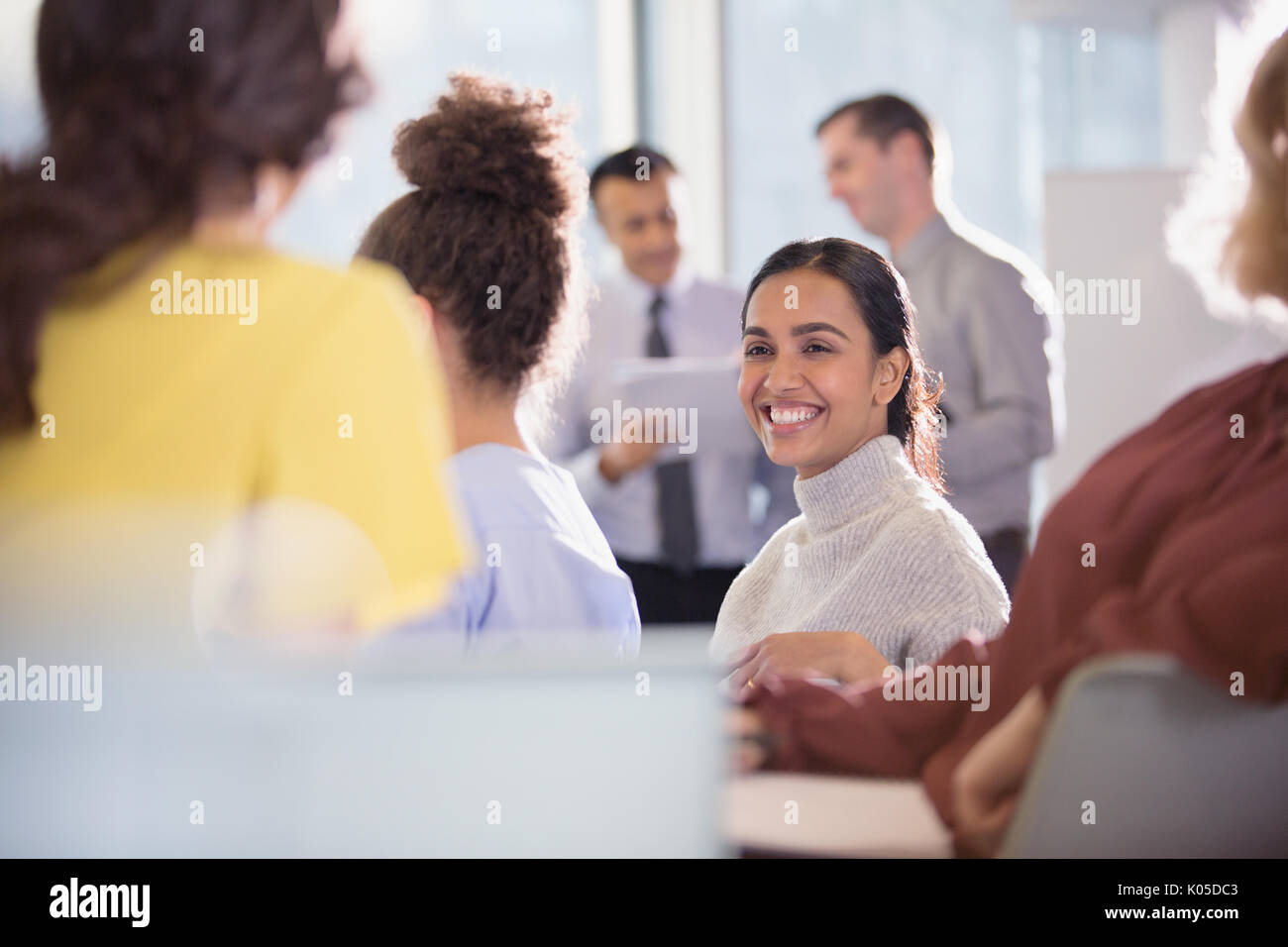 Sorridente imprenditrice parlando con colleghi in udienza di conferenza Foto Stock