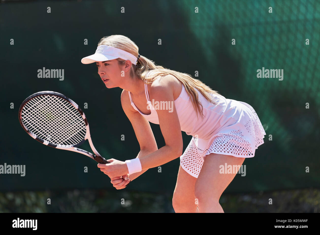 Focalizzato femmina giovane giocatore di tennis pronto, giocare a tennis Foto Stock