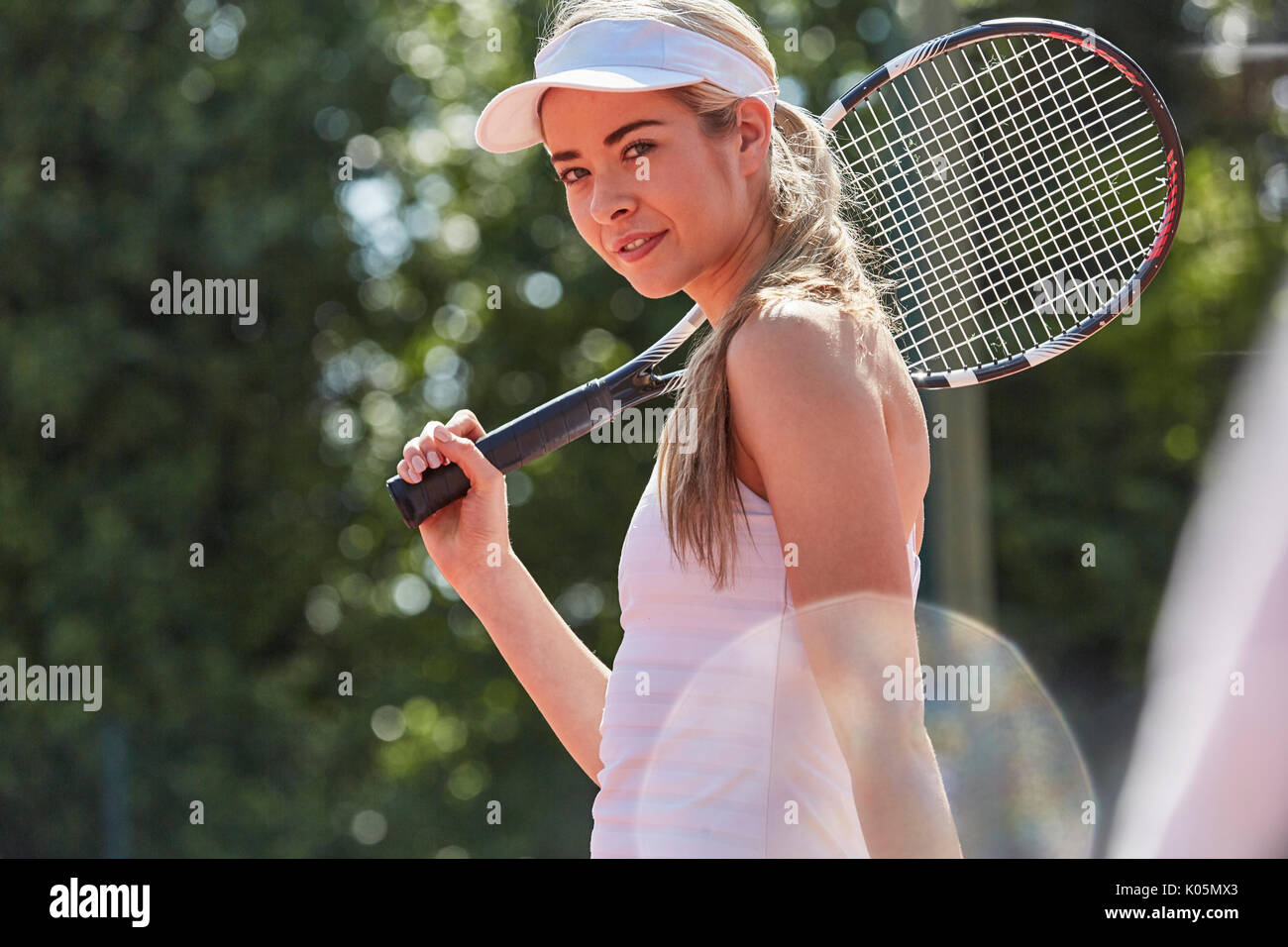 Ritratto fiducioso femmina giovane giocatore di tennis holding racchetta da tennis Foto Stock
