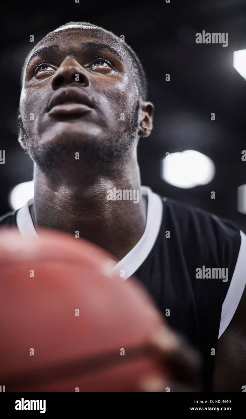 Close up focalizzata maschile giovane giocatore di pallacanestro con basket cercando Foto Stock