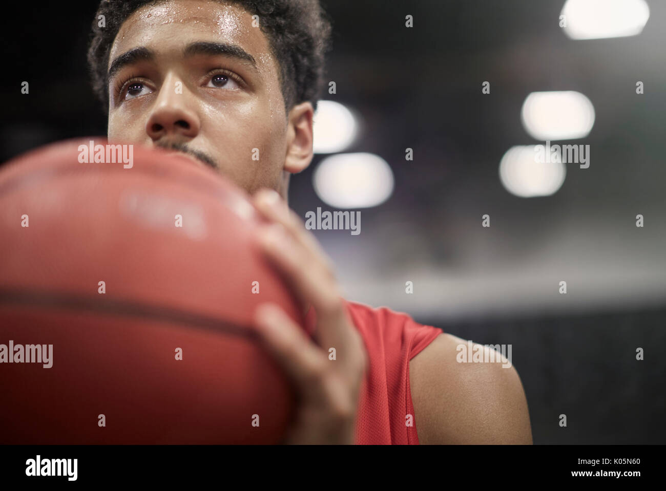Close up focalizzata maschile giovane giocatore di basket tenendo la pallacanestro Foto Stock