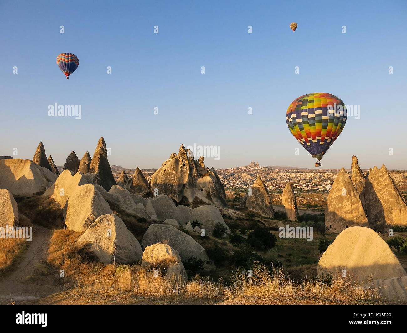 I palloni ad aria calda su formazioni rocciose in Cappadocia Foto Stock