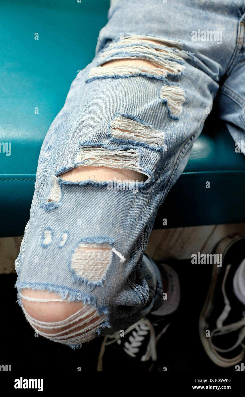 Persona che indossa alla moda jeans strappati Foto Stock