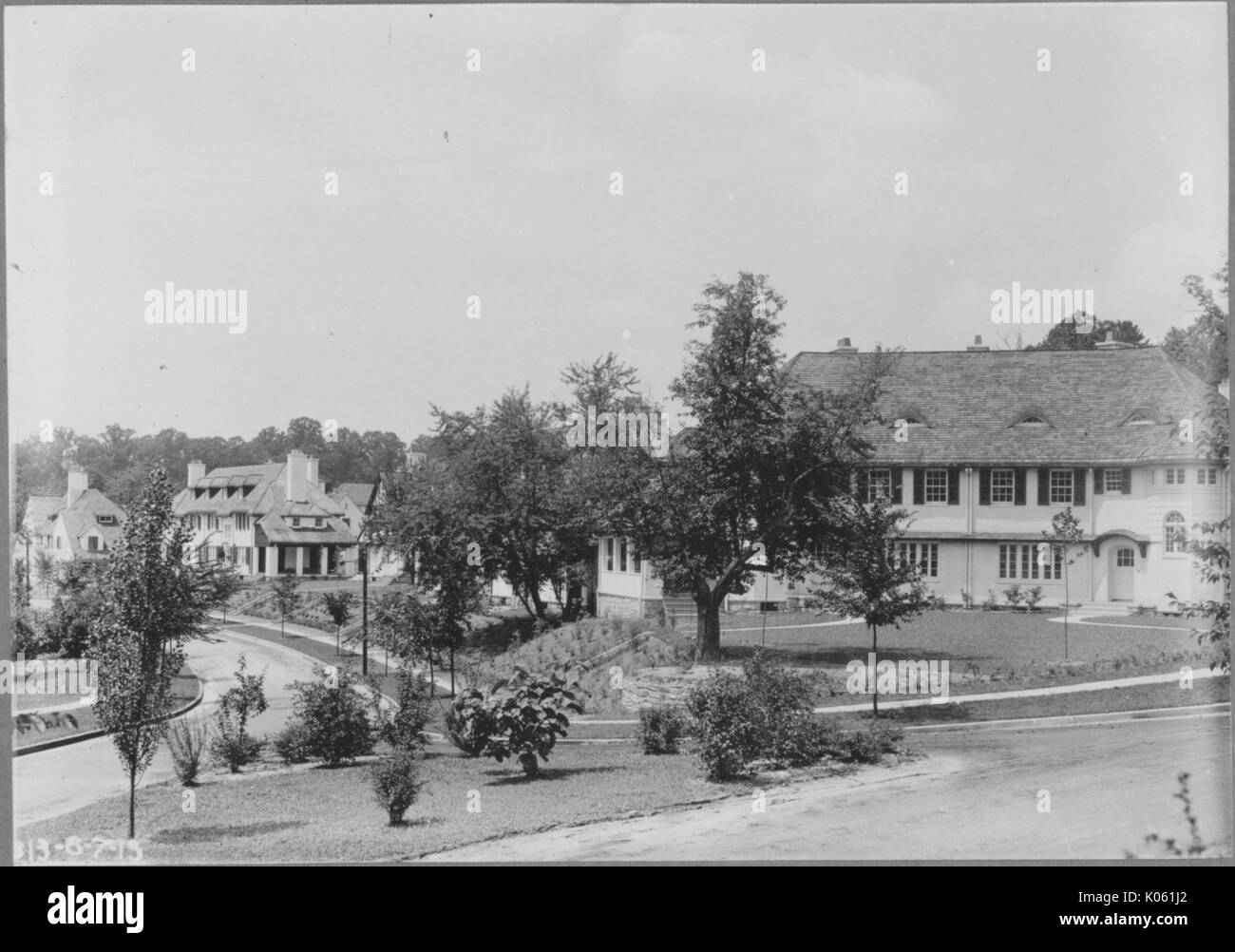 Paesaggio shot, vista aerea di un quartiere con strade intersecanti, una varietà di piccoli e grandi alberi che fiancheggiano la strada, uno grande a due piani casa bianca è chiaramente visibile, Roland parco/Guilford, Stati Uniti, 1910. Questa immagine viene da una serie di documentare la costruzione e la vendita di case nel parco di Roland/Guilford quartiere di Baltimora, un tram sobborgo e una delle prime comunità prevista negli Stati Uniti. Foto Stock