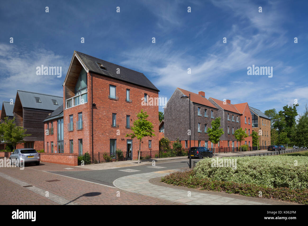 Contemporary Eco-moderno progettato alloggiamento suburbana di sviluppo con alberi che fiancheggiano street in Upton, Sud Ovest distretto, Northampton, Inghilterra. Foto Stock