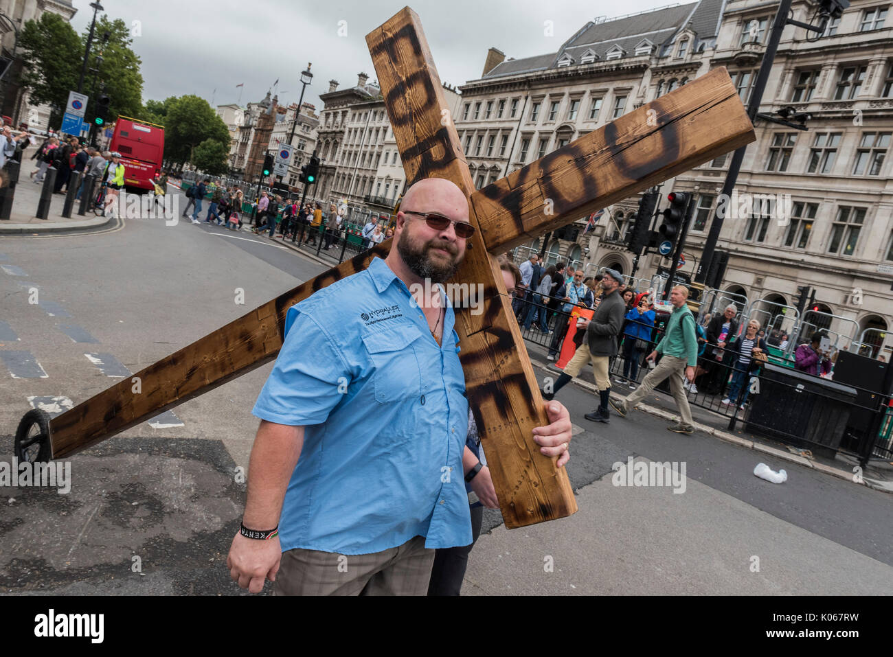 Londra, Regno Unito. 21 Agosto, 2017. Un uomo porta un crocifisso (con una ruota posteriore e teh parole per me per voi di marca su di esso) giù whitehall e in piazza del Parlamento a pochi minuti dopo il Big Ben ha fatto la sua ultima bong, per un certo periodo di tempo. Londra 21 ago 2017. Credito: Guy Bell/Alamy Live News Foto Stock