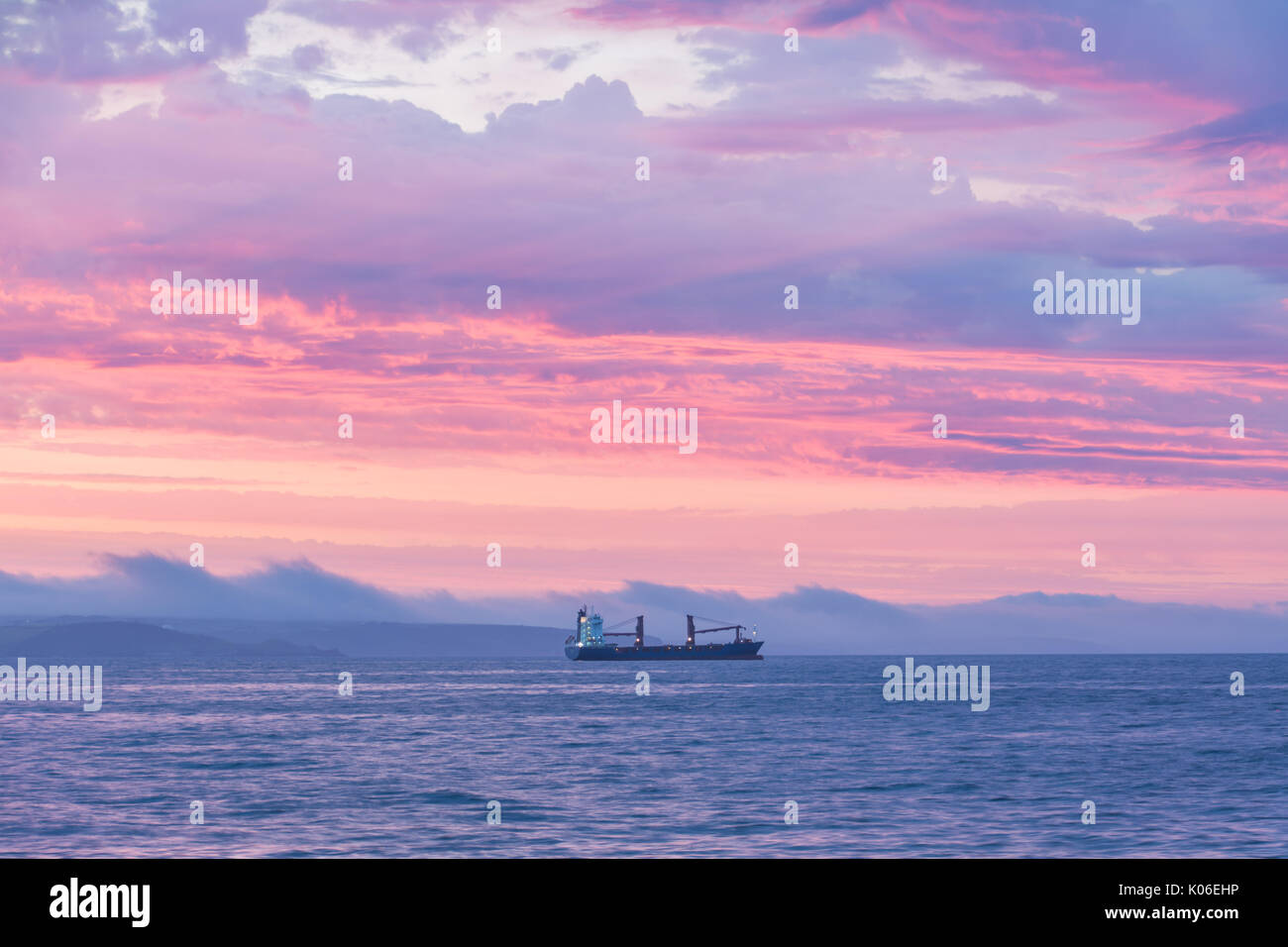 Newlyn, Cornwall, Regno Unito. Il 22 agosto, 2017. Regno Unito Meteo. Era un caldo e colorato per iniziare la giornata a Newlyn in Cornovaglia. Visto qui una barca ancorata in Mounts Bay, con la costa della penisola di Lizard in background. Credito: Simon Maycock/Alamy Live News Foto Stock