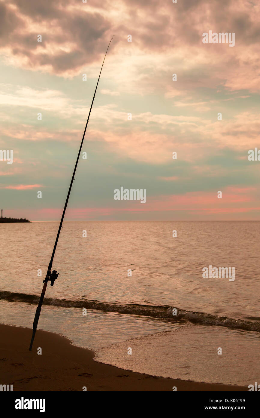 Asta sulla costa del mare pesca notturna al golden sunset Foto Stock