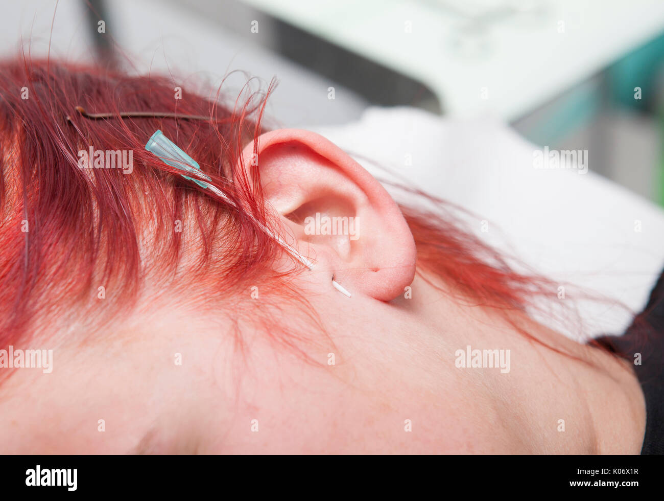 I giovani i Capelli rossi ragazza con cannula trafitto sulla pelle dell'orecchio. Tragus tipo Foto Stock