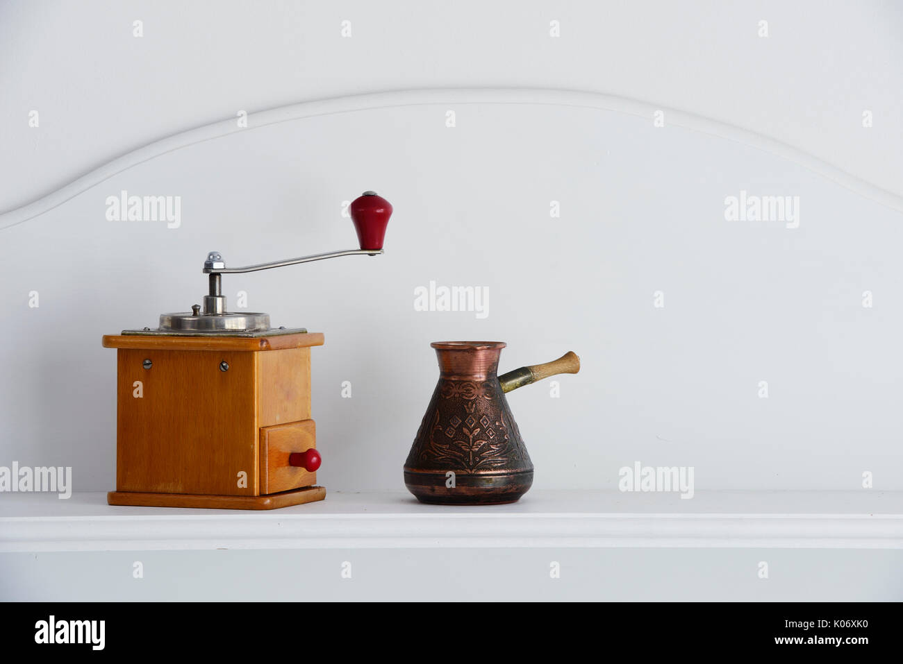 Mano vintage macinino da caffè e vecchi caffè arabo pentola su uno sfondo neutro Foto Stock