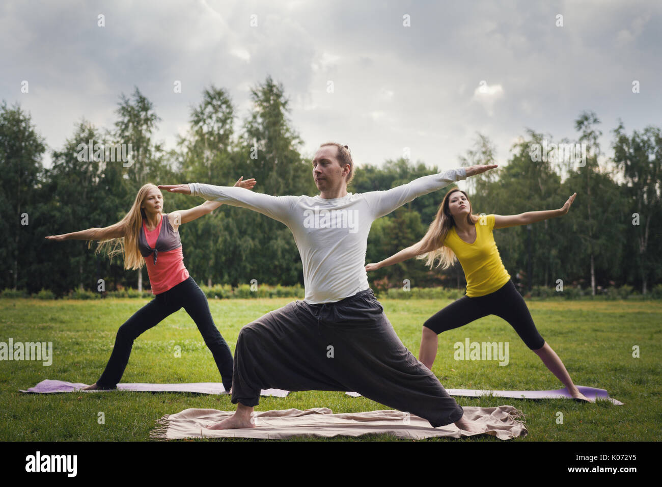 Lo Yoga sportivi nel parco - esegue esercizio all'aperto all'aperto al mattino Foto Stock