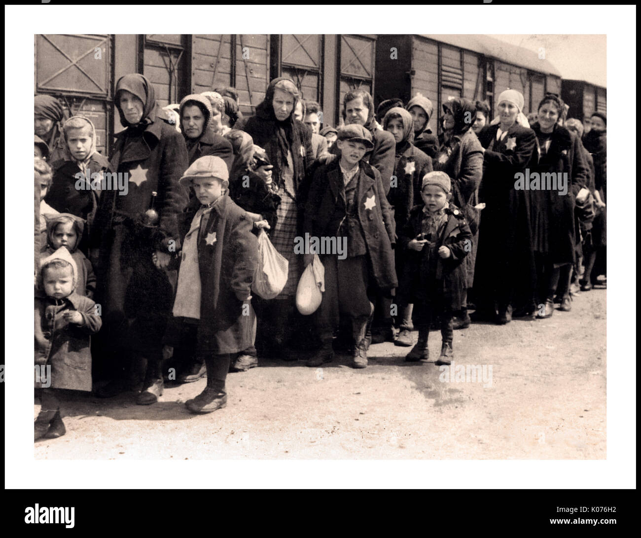 Le donne e i bambini ebrei di Auschwitz-Birkenau che indossano le stelle gialle designate dai nazisti arrivano al campo di concentramento e sterminio tedesco del WW2. I bambini ebrei hanno costituito il gruppo più grande di coloro che sono stati deportati nel campo. Sono stati di solito inviati lì insieme agli adulti, a partire dall'inizio del 1942, come parte della "soluzione finale della questione ebraica" La distruzione totale della popolazione ebraica d'Europa...il campo di concentramento di Auschwitz era una rete di campi di concentramento nazisti tedeschi e campi di sterminio gestiti dal terzo Reich nelle aree polacche annesse dalla Germania nazista durante la seconda guerra mondiale Foto Stock