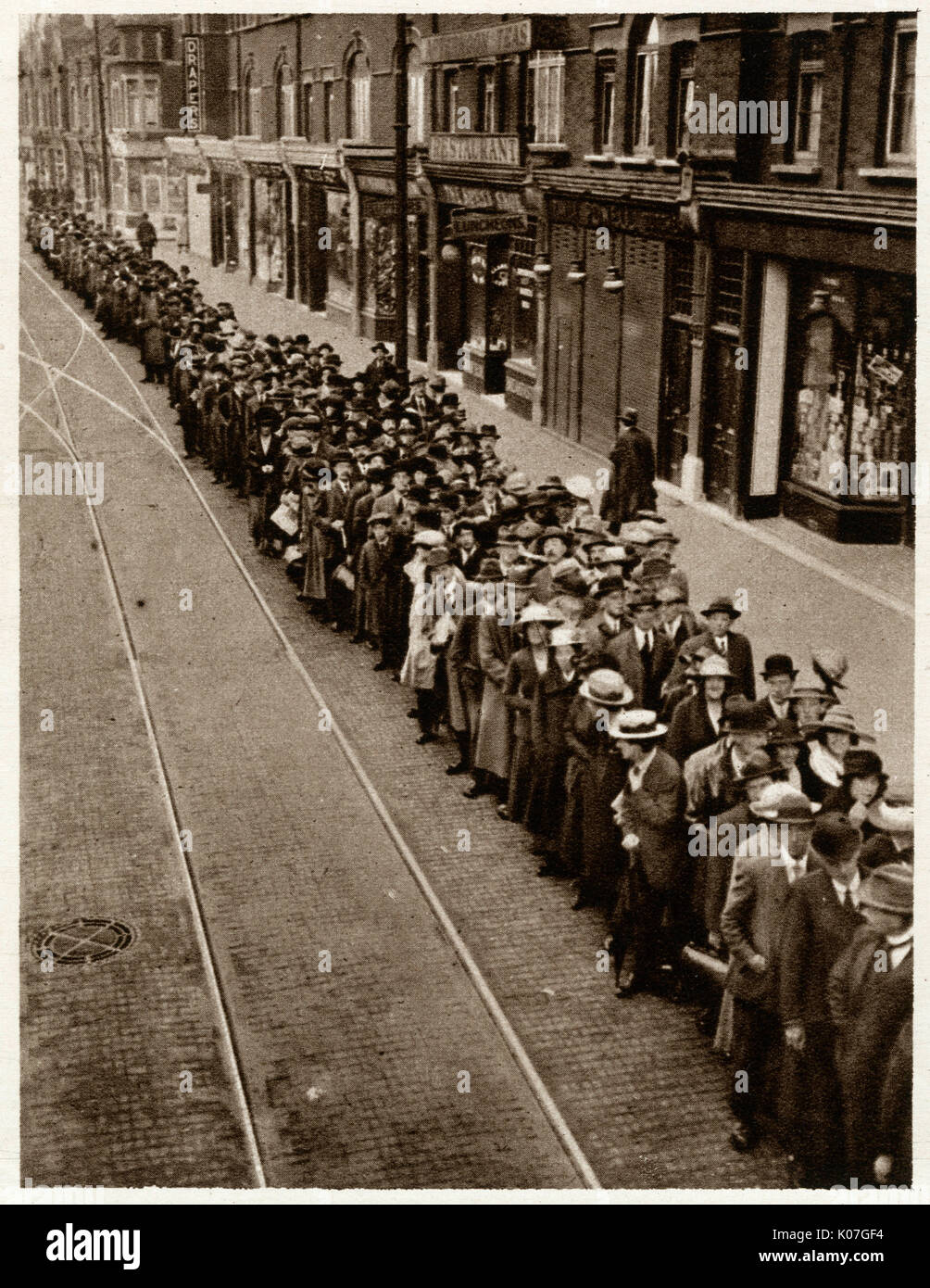 Centinaia di pendolari a Londra queing pazientemente per la già oltre utilsed tram. Data: Ottobre 1919 Foto Stock