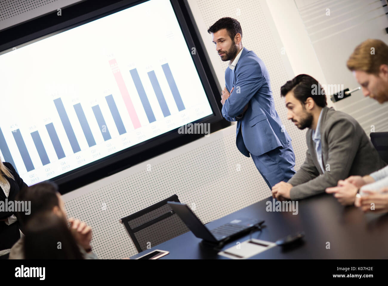 Giovane imprenditore attraente che mostra la presentazione ai suoi colleghi Foto Stock