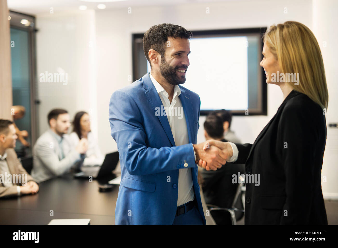 Imprenditore e imprenditrice agitando mani alla riunione Foto Stock