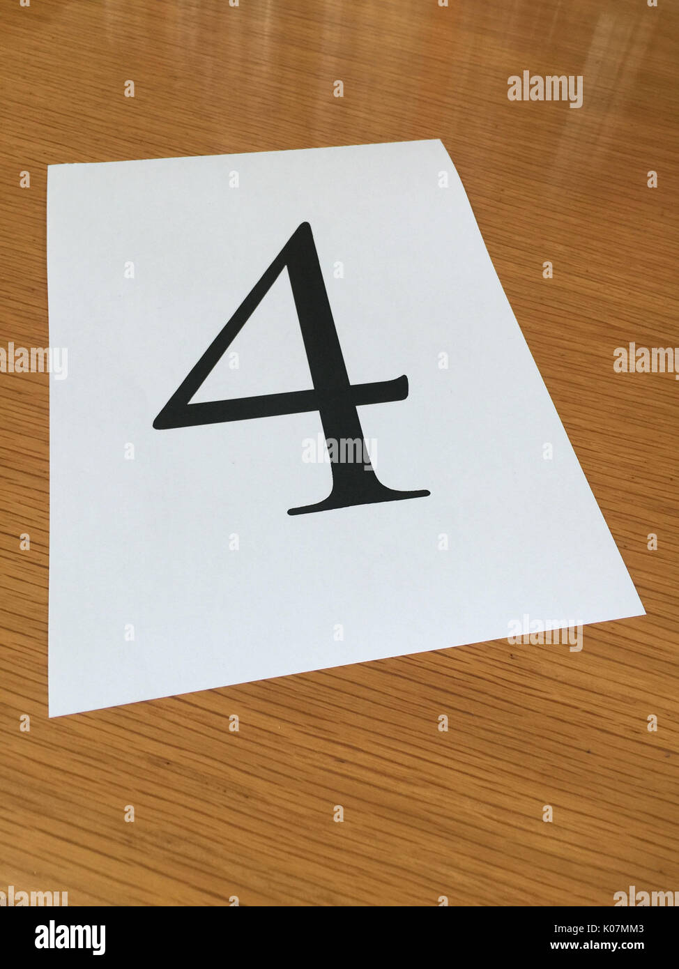 Pezzo di carta su una scrivania con un grande numero 4 Foto Stock