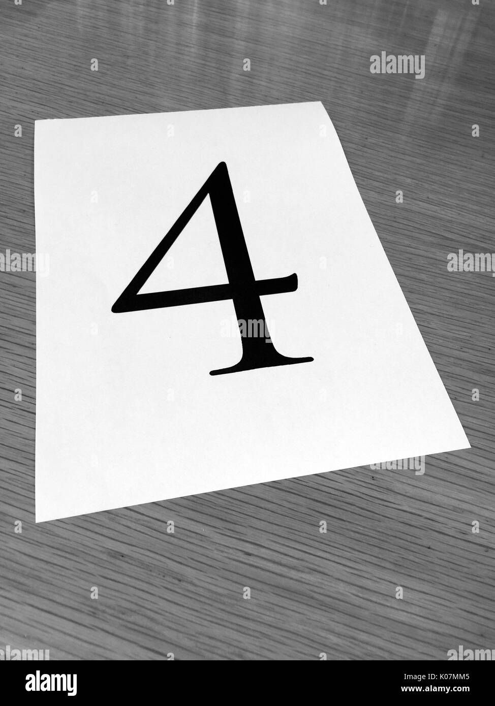 Pezzo di carta su una scrivania con un grande numero 4 Foto Stock
