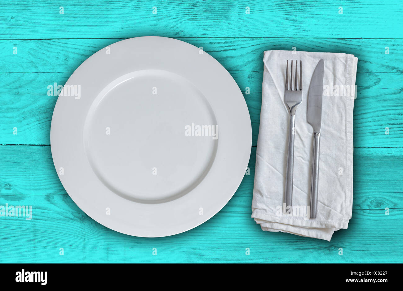 Piastra vuota con posate sulla benzina Sfondo legno. Foto Stock