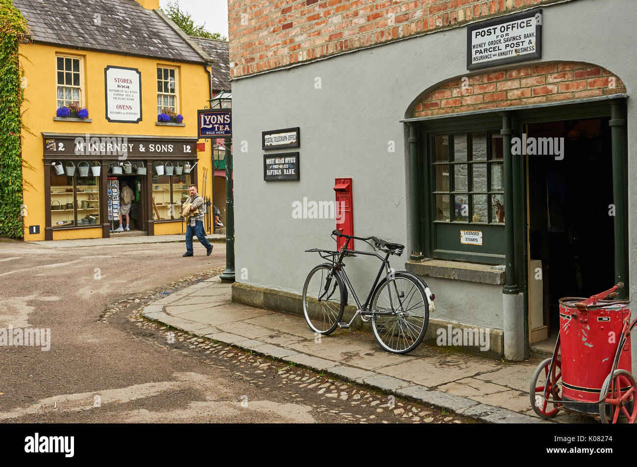Bicicletta appoggiata contro la parete di un ufficio postale in Bunratty folk park Foto Stock
