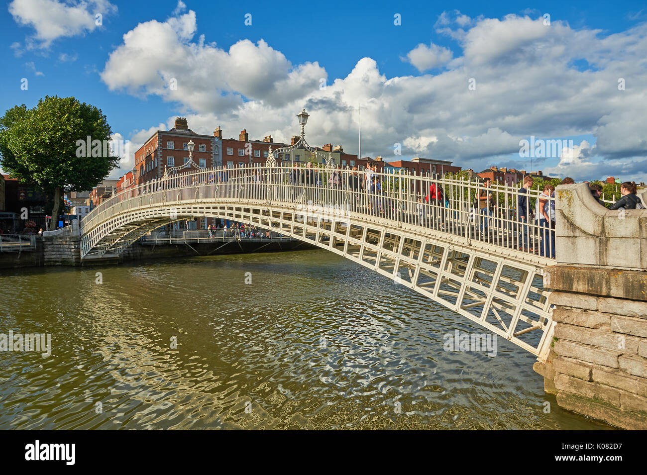 Pedoni che attraversano l'iconico Ha'penny Bridge sul fiume Liffey nel centro di Dublino, Irlanda Foto Stock