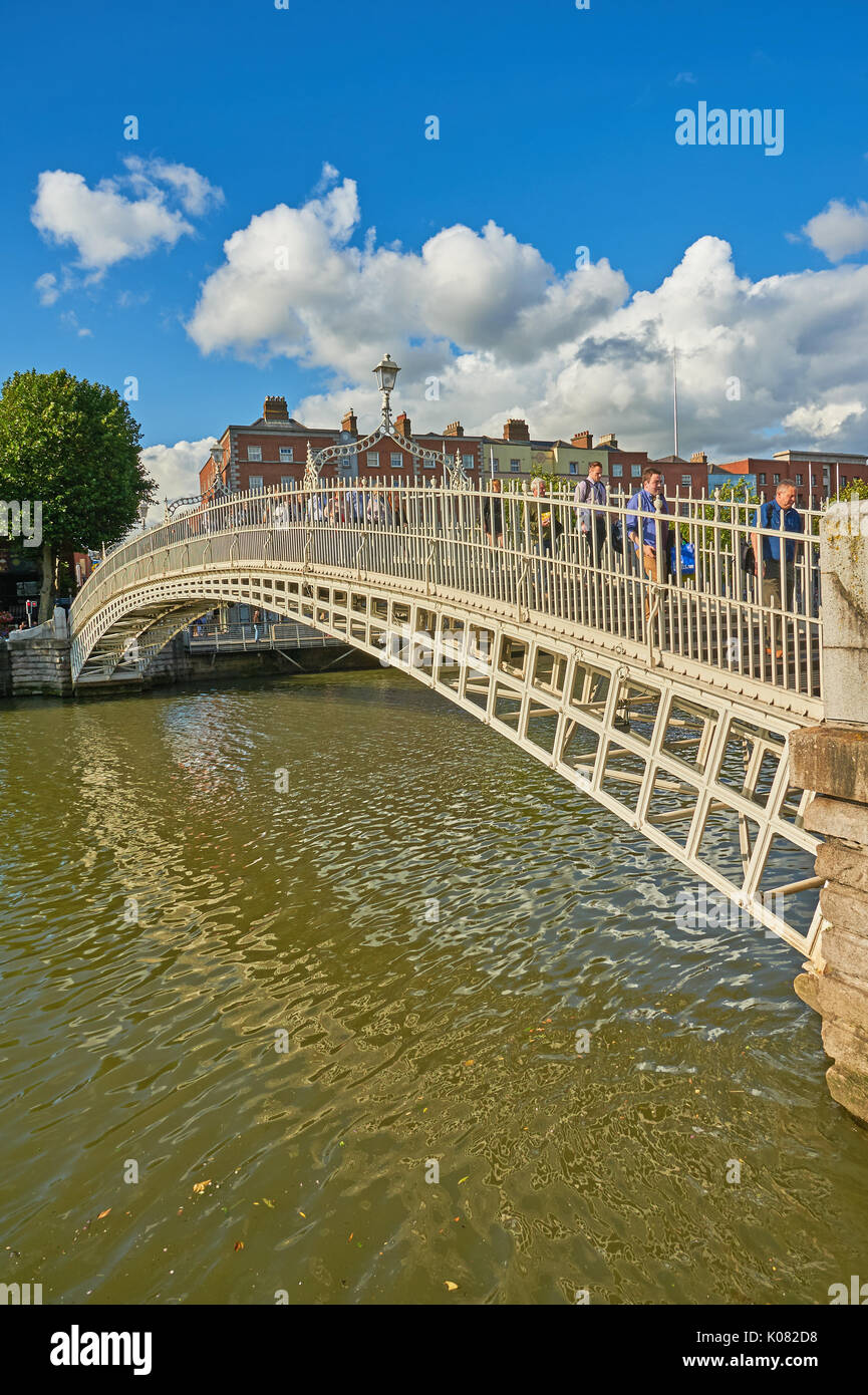 Pedoni che attraversano l'iconico Ha'penny Bridge sul fiume Liffey nel centro di Dublino, Irlanda Foto Stock