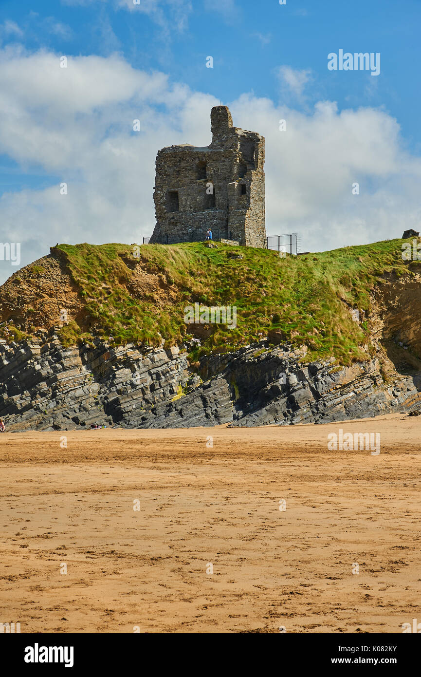Le rovine del castello di Ballbunion nella Contea di Kerry guardano alla vasta spiaggia di sabbia e l'Oceano Atlantico su una tranquilla giornata estiva. Foto Stock