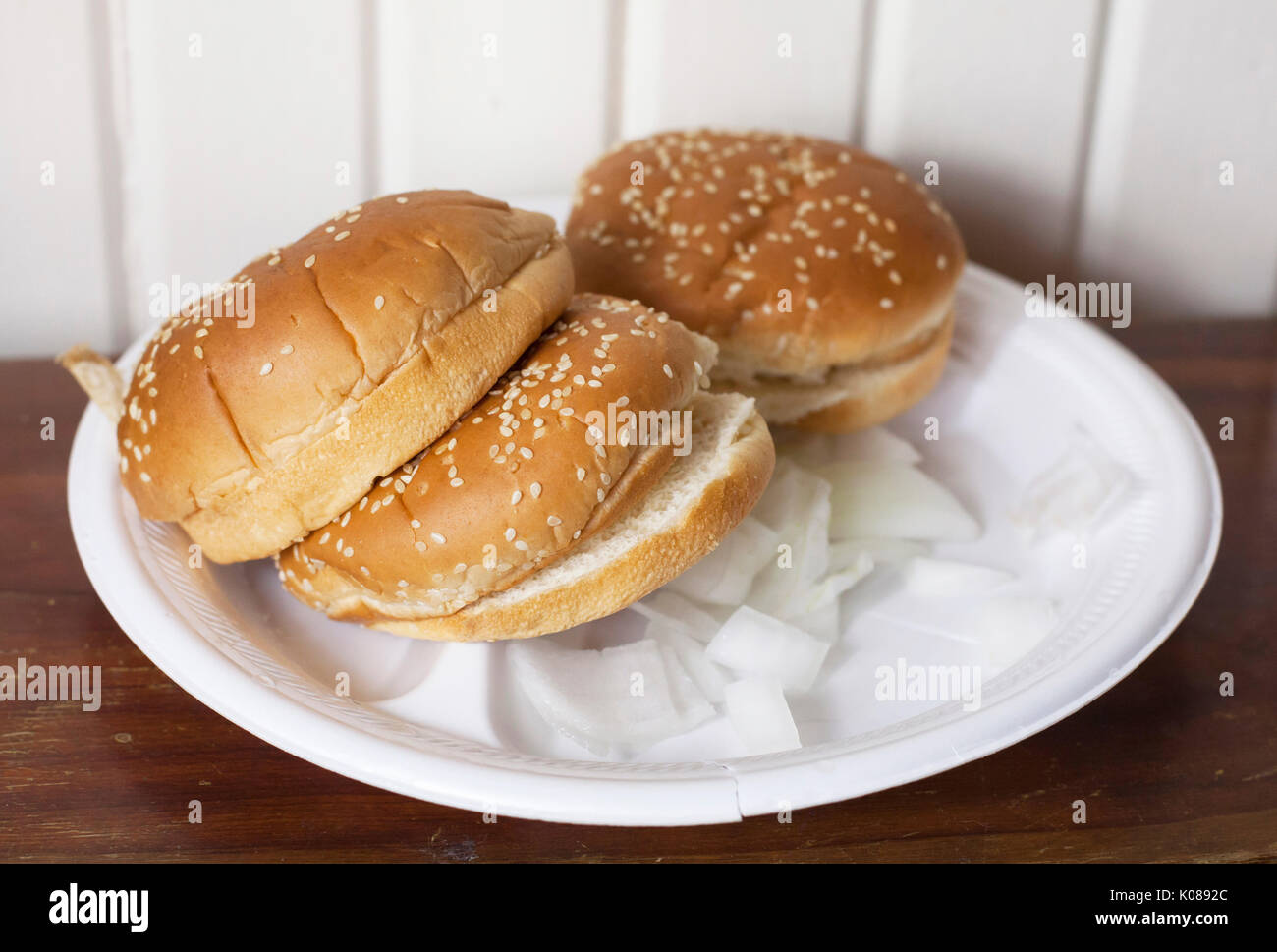 Tre set di hamburger panini su una piastra con cipolle Foto Stock