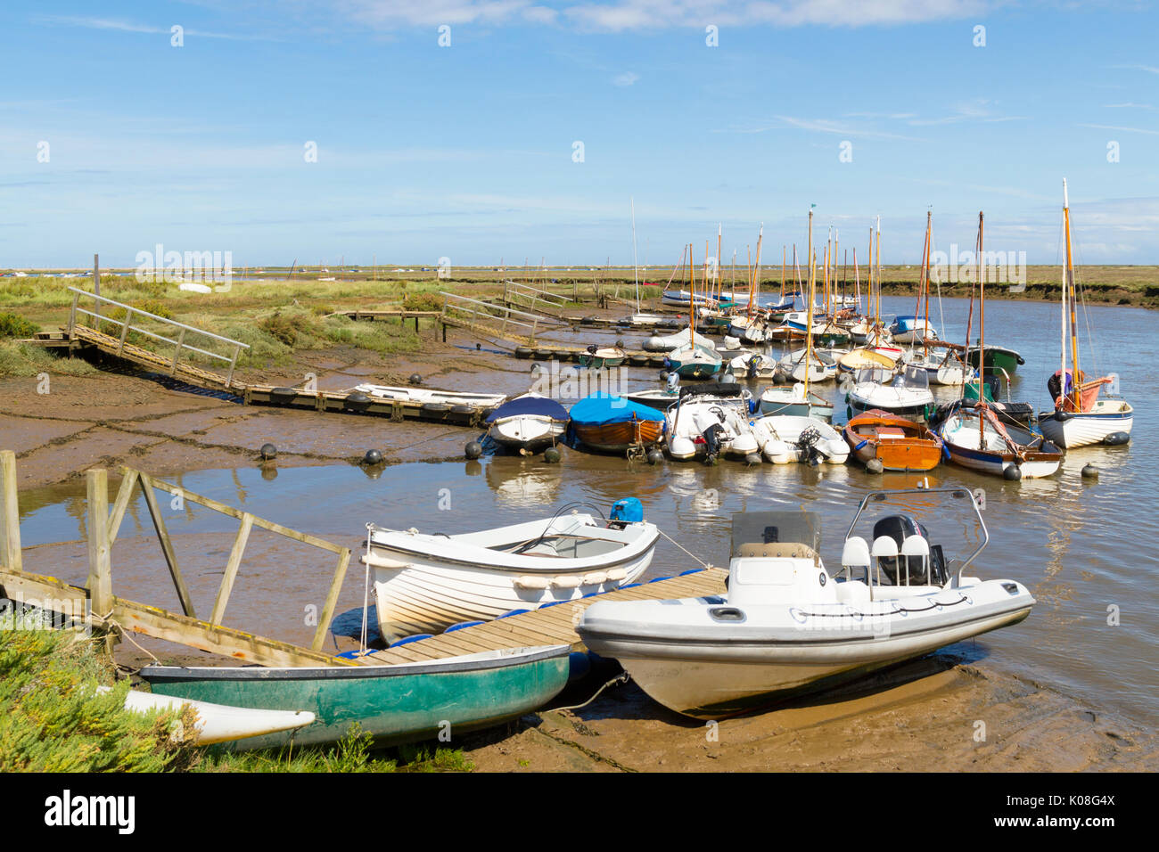 Barche ormeggiate in Morston Creek Norfolk con la marea out Foto Stock