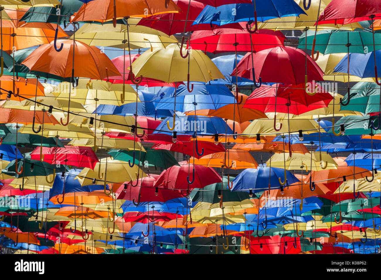 Aperto ombrelloni colorati con una parte di cielo blu galleggianti in aria Foto Stock