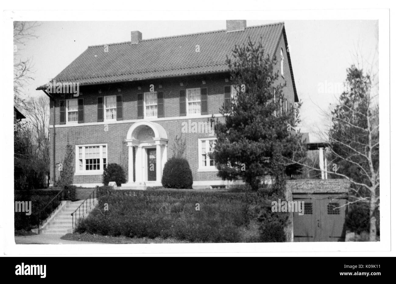Vista anteriore angolare di una singola famiglia di mattoni casa nei pressi di Guilford, la casa è a due piani e ha staccato un garage al piano seminterrato della casa, Baltimore, Maryland, 1910. Questa immagine viene da una serie di documentare la costruzione e la vendita di case nel parco di Roland/Guilford quartiere di Baltimora, un tram sobborgo e una delle prime comunità prevista negli Stati Uniti. Il quartiere era segregato ed è considerato uno dei primi esempi di applicazione della segregazione razziale attraverso l'uso limitato di patti. Foto Stock