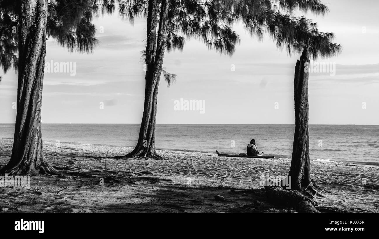 Donna seduta da sola, guardando il mare. Foto Stock