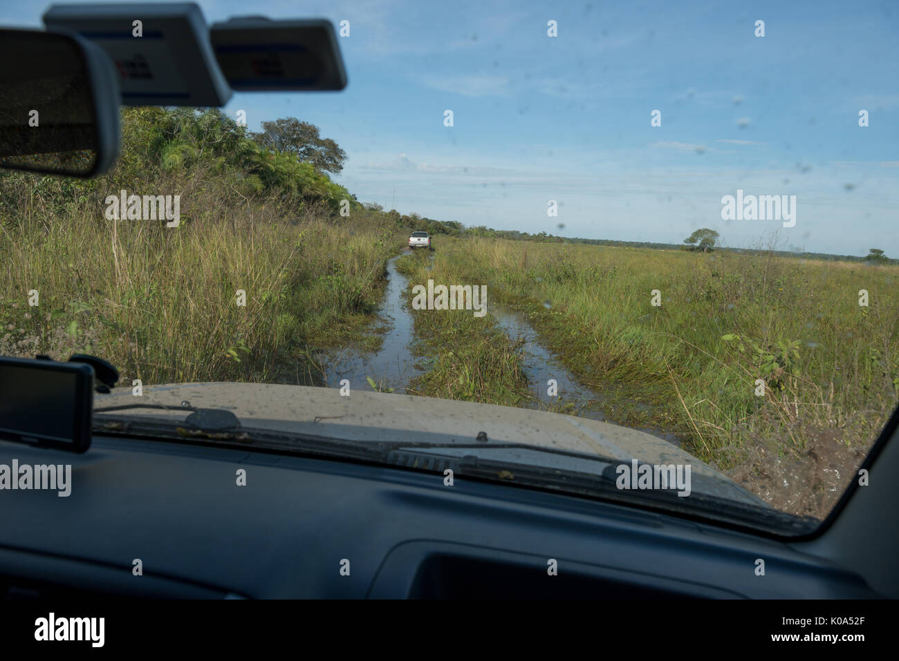 4x4 car guida attraverso parzialmente allagate road nel pantanal Foto Stock