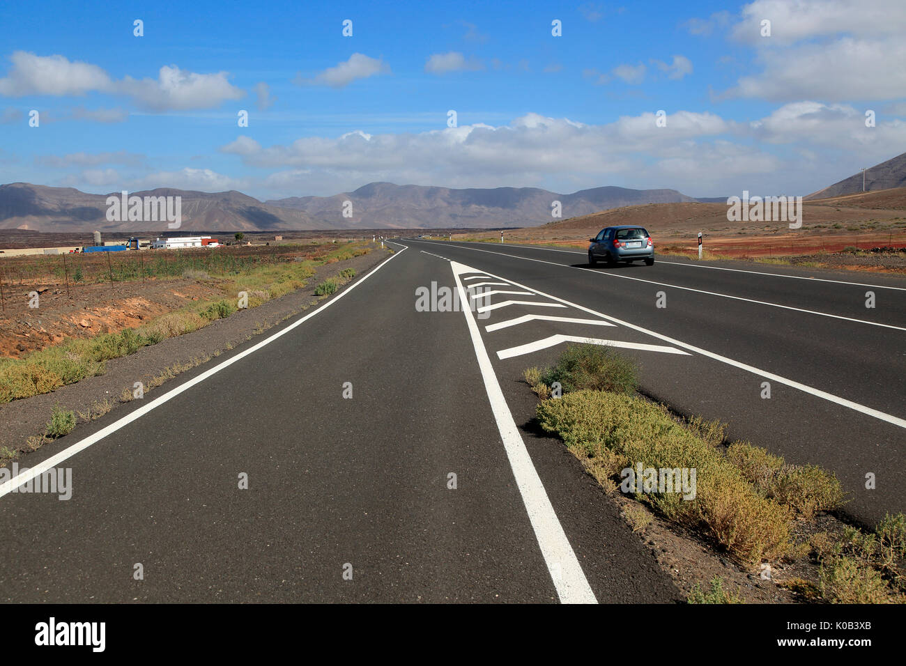 Chevron road linee sulla principale autostrada attraverso Malpaís Grande parco nazionale, Fuerteventura, Isole Canarie, Spagna Foto Stock