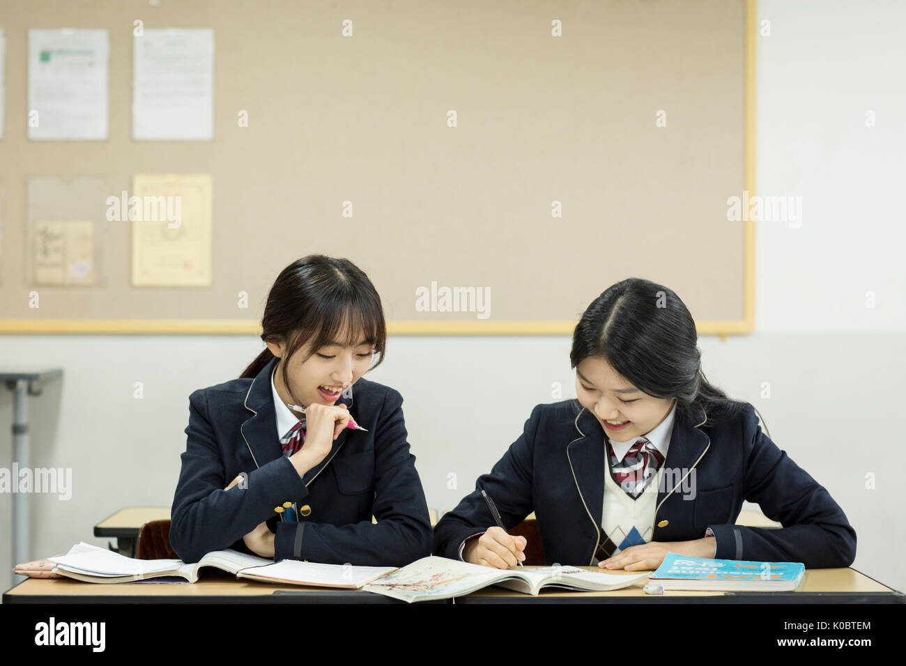 Ritratto di due sorridenti ragazze della scuola in aula Foto Stock