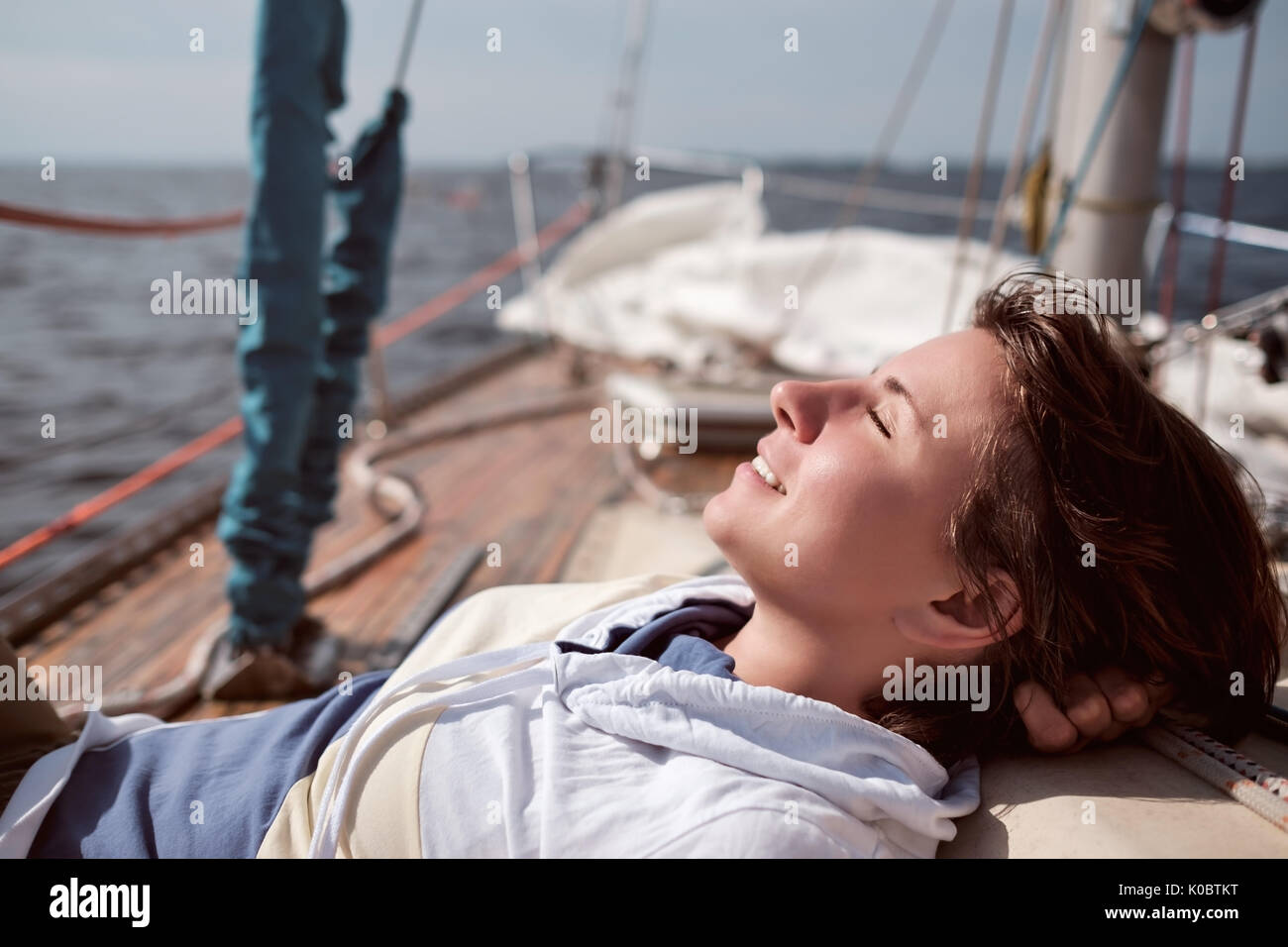 La donna caucasica yachting in mare. Lei chiude gli occhi e sogni Foto Stock