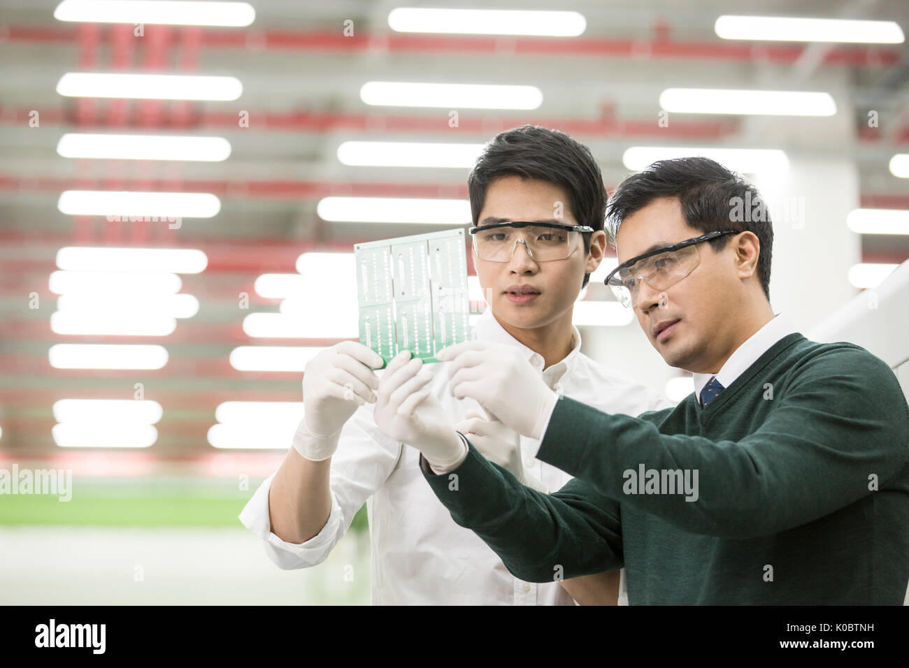 Ritratto di due scienziati appassionato di contenimento e osservando il circuito stampato Foto Stock