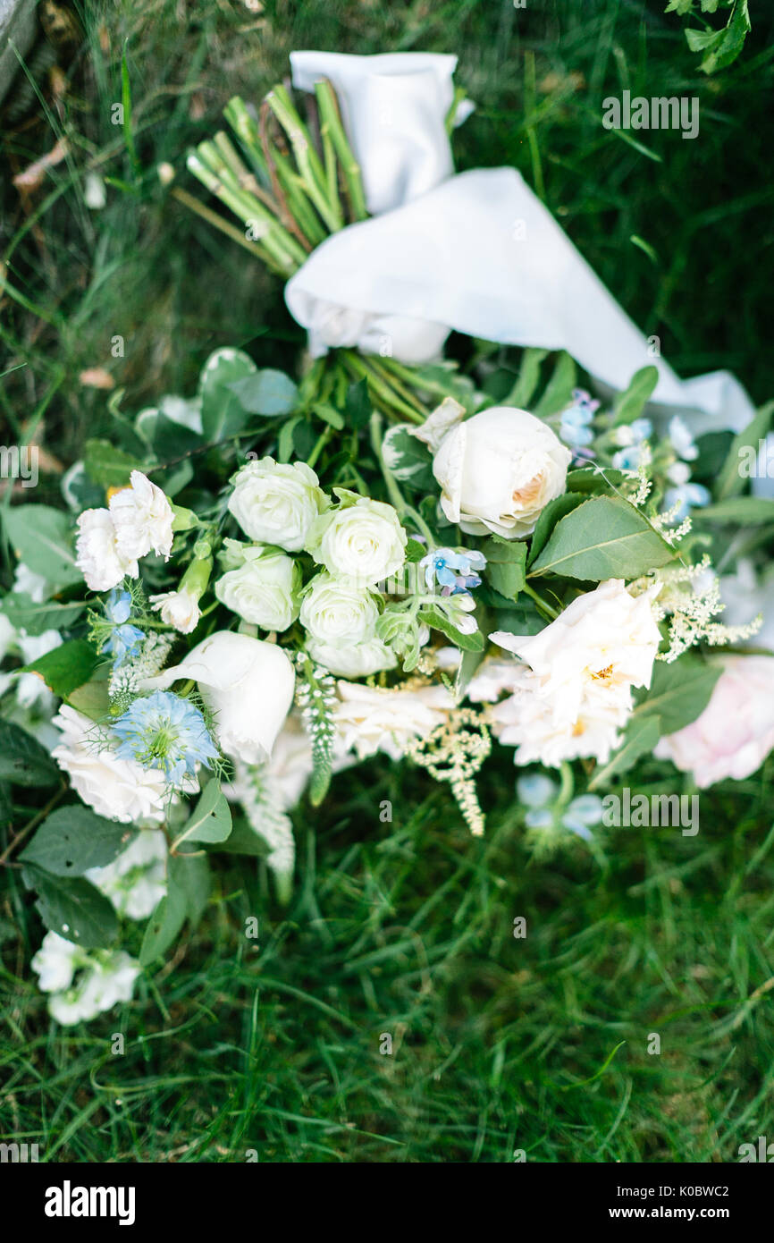 Celebrazione. Il matrimonio, la molla concetto. nella fresca erba verde vi  è bouquet della sposa composto da eleganti rose e garofani meravigliosa nel  tradizionale di colore bianco Foto stock - Alamy