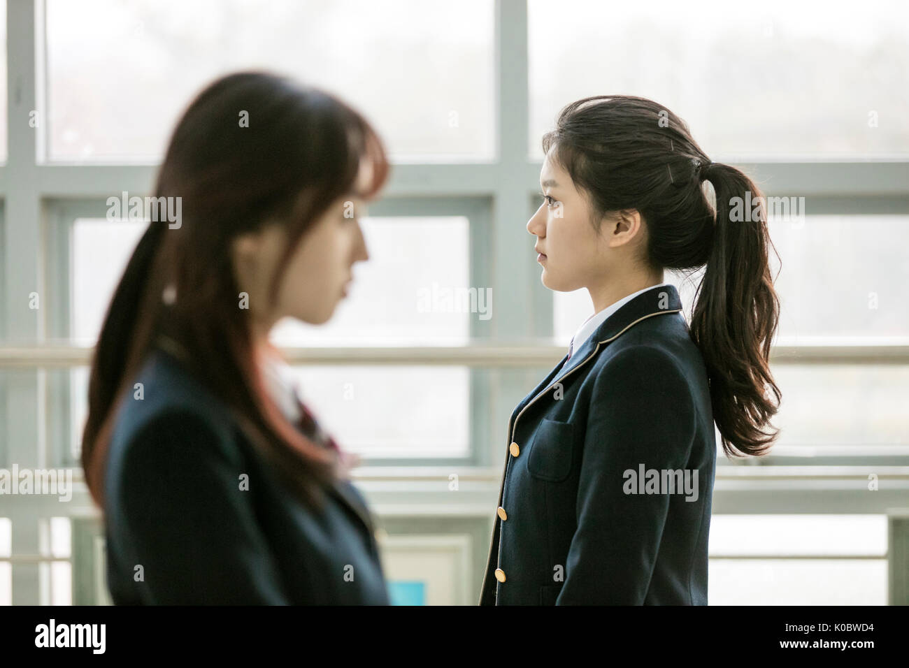 Vista laterale verticale della scuola ragazze con facce inespressive Foto Stock