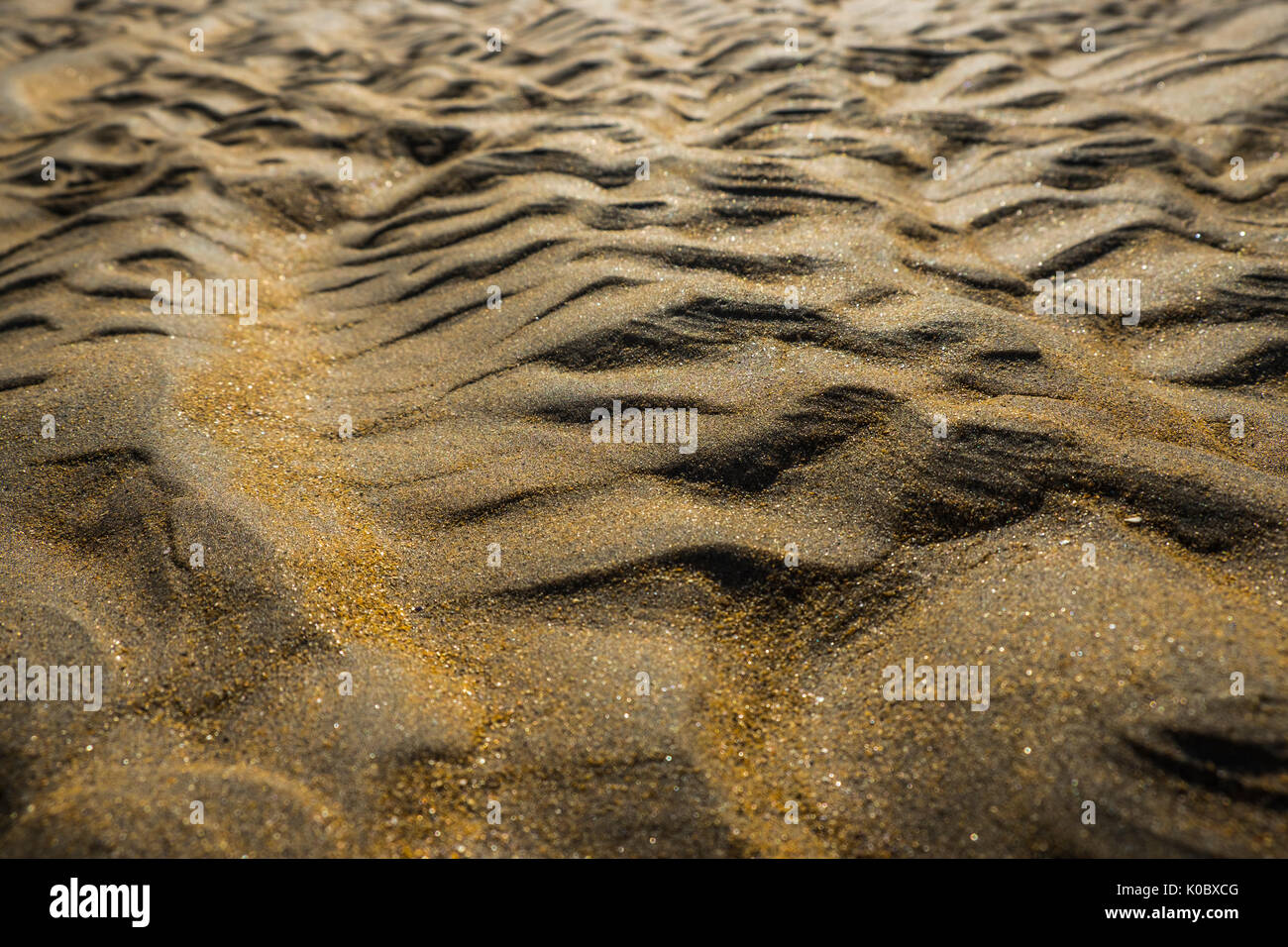 Close up di sabbia di una spiaggia - paesaggi alieni, simile a Marte, rosso, oro Foto Stock