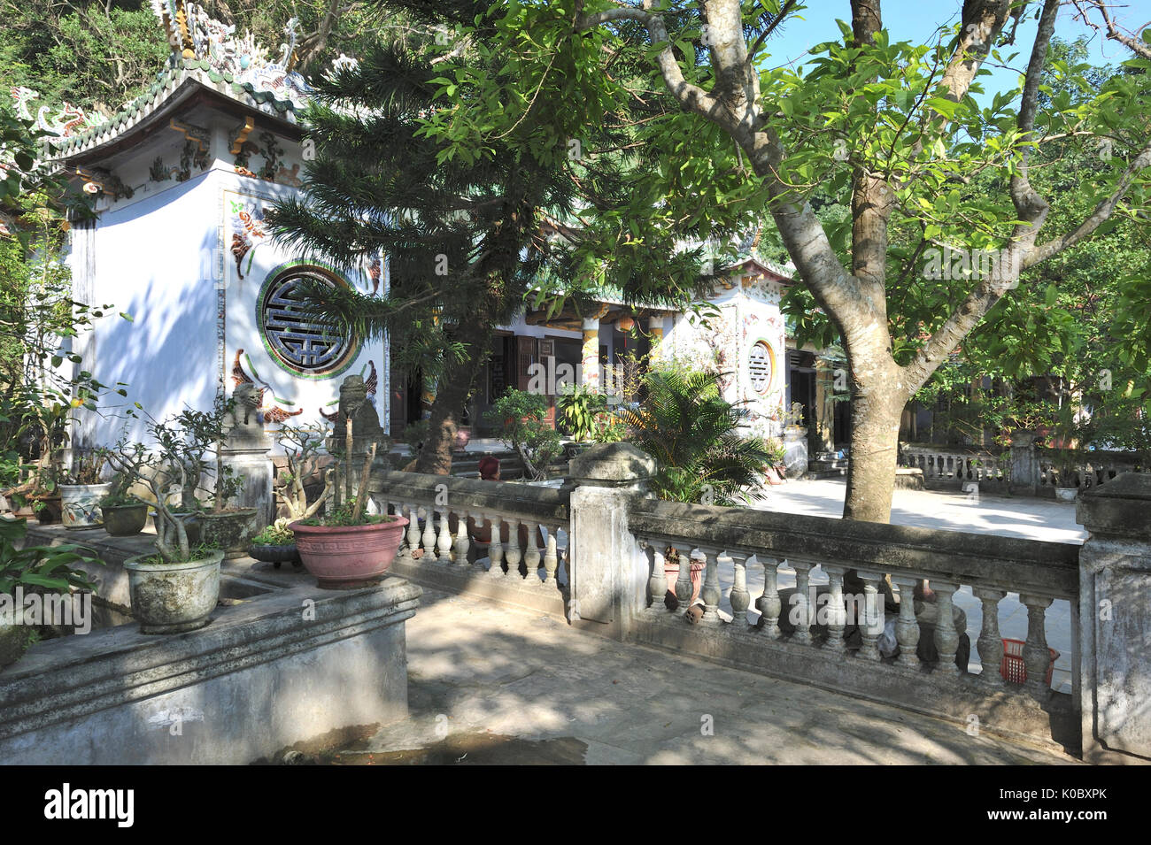 Vista della pagoda principale con all'interno del santuario, anziani donna seduta al di fuori. Linh Ung Non Nuoc Pagoda. Da Nang. Il Vietnam Foto Stock