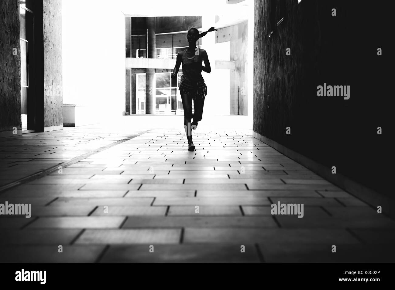 Giovane donna in esecuzione su strada in ambiente urbano Foto Stock